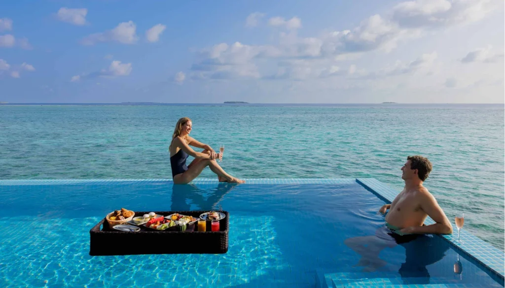 pareja con desayuno flotante en pool villa en Maldivas
